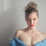 belle-photo-jolie-femme-portant-du-rouge-levres-appuye-contre-mur_181624-27948