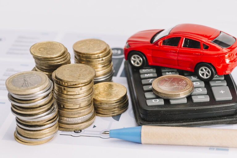 pile-de-pieces-de-monnaie-calculatrice-voiture-jouet-et-stylo-sur-le-gabarit